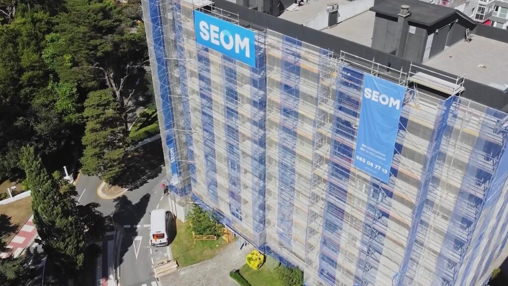 Vista aérea de un edificio en rehabilitación con andamios y lonas de SEOM en Donostia